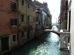 ein kleiner Kanal mit einer Brücke in einer Stadt in der Unterkunft Cà Bollani in Venedig