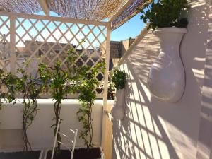 a white vase on a white fence with plants at Casa Sultana in Favignana