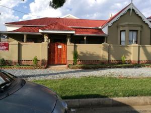 ein Haus mit rotem Dach und einem Auto vor dem Haus in der Unterkunft Guesthouse@Mbalistar in Queenstown