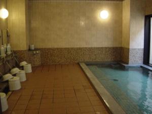 baño con piscina y aseos. en Hotel Route-Inn Aso Kumamoto Airport Ekimae, en Ozu
