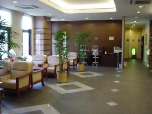 a lobby with a waiting room with plants and chairs at Hotel Route-Inn Aso Kumamoto Airport Ekimae in Ozu +42 photos