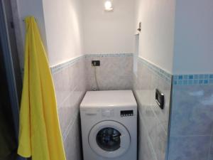 a washing machine in a bathroom with a yellow towel at HouseInGenoaCenter2 Parking in Genova