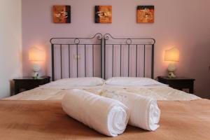 1 dormitorio con 2 camas con sábanas y almohadas blancas en B&B Regina Carolina, en Caltagirone