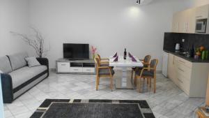 ショプロンにあるFüredi Ház apartmanのキッチン、リビングルーム(テーブル、椅子付)