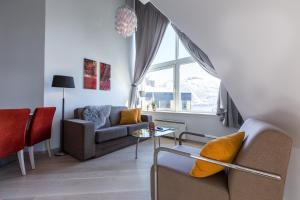 a living room with a couch and a window at First Hotel City Tromsø in Tromsø