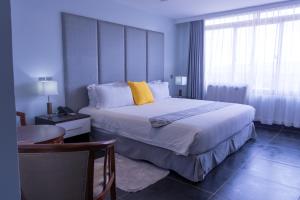 ein Schlafzimmer mit einem großen Bett mit gelben Kissen in der Unterkunft Gelian Hotel in Machakos