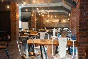 a restaurant with tables and chairs and a brick wall at Macdonald Aviemore Hotel at Macdonald Aviemore Resort in Aviemore