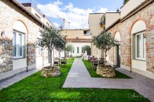une cour avec des chaises et des arbres dans un bâtiment dans l'établissement Alloggi Palmini, à Florence
