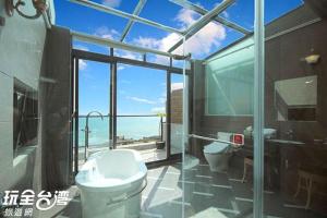 a bathroom with a toilet and a view of the ocean at Jing Guan Hotel in Eluan