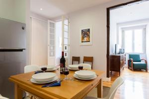a dining room with a wooden table with glasses of wine at ALTIDO Inviting flat next to Carmo Convent in Lisbon