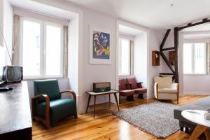 a living room with chairs and a tv in it at ALTIDO Inviting flat next to Carmo Convent in Lisbon