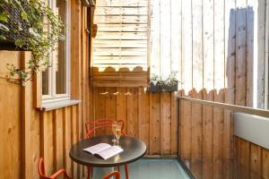 einen kleinen Tisch und Stühle auf einer Terrasse mit einem Fenster in der Unterkunft Appartements Cathédrale - YBH in Bordeaux