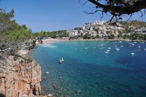 uma vista para uma praia com barcos na água em Apartamento Cala Montgó em L'Escala