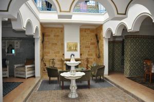 a room with a table and chairs in a building at Dar El Kasba Riad Guest House in Bizerte