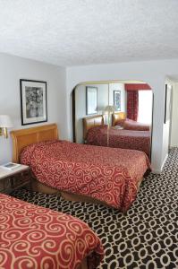 a hotel room with two beds with red sheets at Delos Reyes Palm Springs in Palm Springs +51 photos