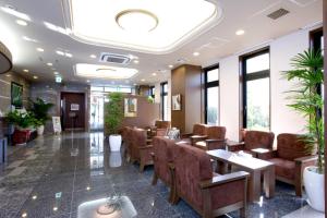 a waiting room with chairs and tables and windows at Hotel Route-Inn Nobeoka Ekimae in Nobeoka