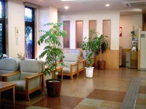 a hospital waiting room with chairs and potted plants at Hotel Route-Inn Ogaki Inter in Ogaki