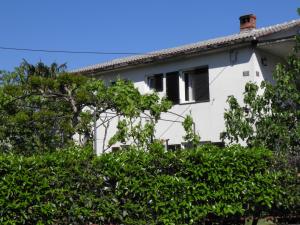 a white house with a window and trees at Apartment Gogo in Opatija