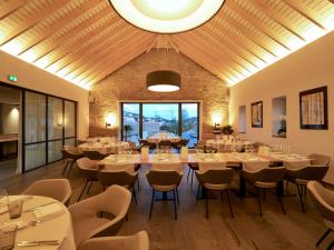 Hostellerie Stafelter في Walferdange: غرفة طعام بها طاولات وكراسي وسقف كبير