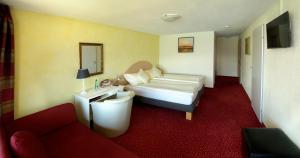 ein Hotelzimmer mit einem Bett und einem Sofa in der Unterkunft Hotel Restaurant Panorama in Aeschlen