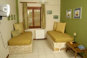 a living room with two beds and a window at Filoxenia Studios in Galaxidi