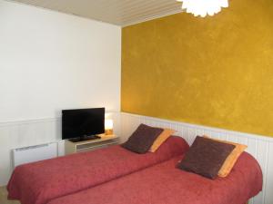 a bedroom with two beds and a flat screen tv at Lapin Kutsu Apartments in Saariselka