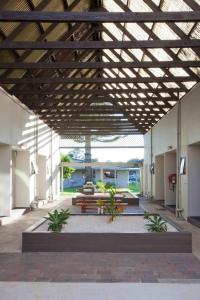 un pavillon avec un banc et des tables dans un bâtiment dans l'établissement Auckland Airport Kiwi Motel, à Auckland