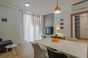 a living room with a table with chairs and a tv at Bell Apartment in Zadar