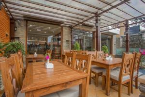 una sala da pranzo con tavoli e sedie in legno di Pokhara Batika a Pokhara