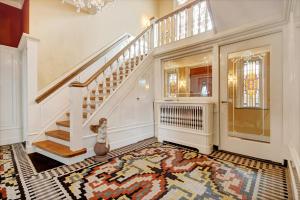 a foyer with a staircase and a rug at 't Heerenhuys in Wageningen