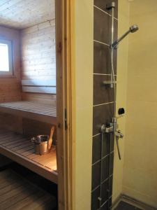 a sauna with a shower and a bench in a room at Lapin Kutsu Apartments in Saariselka