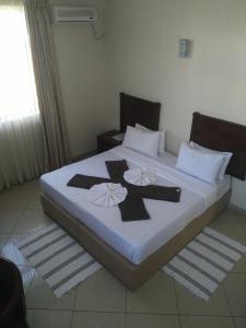 a bedroom with a large bed with black crosses on it at Pensao Marhaba Residencial in Maputo +6 photos