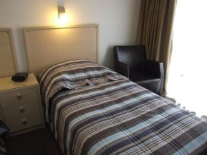 
a bedroom with a bed, chair and lamp at Streaky Bay Hotel Motel in Streaky Bay
