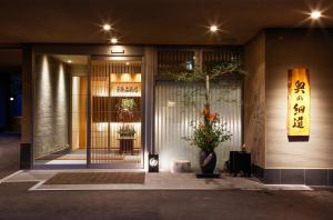 uma porta da frente de um edifício com uma planta num vaso em Okuno Hosomichi em Kobe