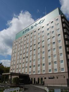 a large building with a sign on the side of it at Hotel Route-Inn Nabari in Nabari