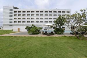 a large white building with a lawn in front of it at Hotel Naveen Lakeside in Hubli