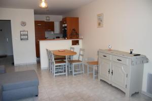 eine Küche und ein Esszimmer mit einem Tisch und Stühlen in der Unterkunft les terrasses de Dahouet in Pléneuf-Val-André