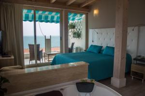 a bedroom with a bed and a view of the ocean at Tysandros Hotel Apartments in Giardini Naxos