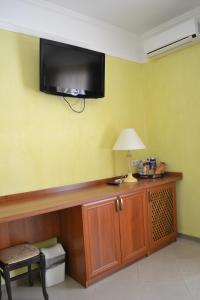 een kamer met een tv aan de muur en een bureau bij Hotel Strike in Vinnytsya