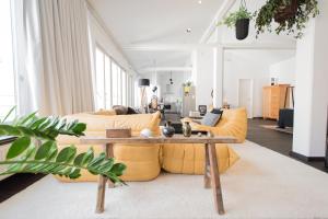 salon z żółtymi kanapami i stolikiem kawowym w obiekcie Weimar Central Artist Loft - 120 m2 w mieście Weimar