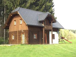 dom z czarnym dachem i placem zabaw w obiekcie Chalet zur Schmiede w mieście Liebenfels
