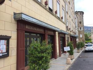 a building with a restaurant sign on the side of a street at Logis Hôtel Restaurant de la Paix in Lodève