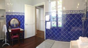 ein Badezimmer mit einer blau gefliesten Wand in der Unterkunft Le Jardin Des Erables in Saint-Marcel