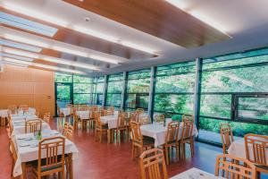 a restaurant with white tables and chairs and windows at Bildungshaus St. Hippolyt in Sankt Pölten