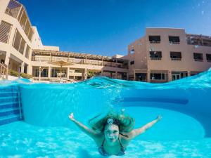a woman swimming in the water in a swimming pool at The Breakers Diving and Surfing Lodge Soma Bay in Hurghada