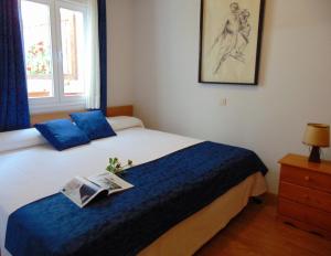 Un dormitorio con una cama con un libro encima. en El Rincón de Antonio, en Casarrubios del Monte