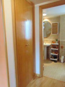Un baño con puerta de madera y lavabo. en El Rincón de Antonio, en Casarrubios del Monte 37 fotos más