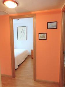 a bedroom with an orange wall and a bed at El Rincón de Antonio in Casarrubios del Monte