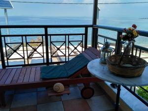 a bench on a balcony with a view of the ocean at 9 Musses Studios in Skala Mistegnon