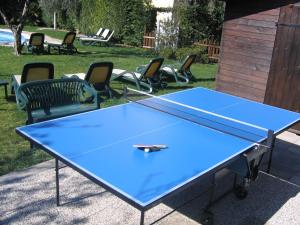 a blue ping pong table with chairs around it at Residence Villa degli Aranci in Riva del Garda